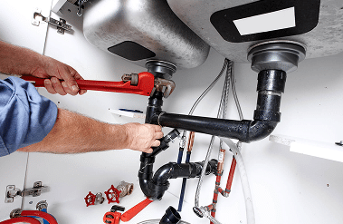 Plumber repairing a sink drain pipe in Shreveport, LA.