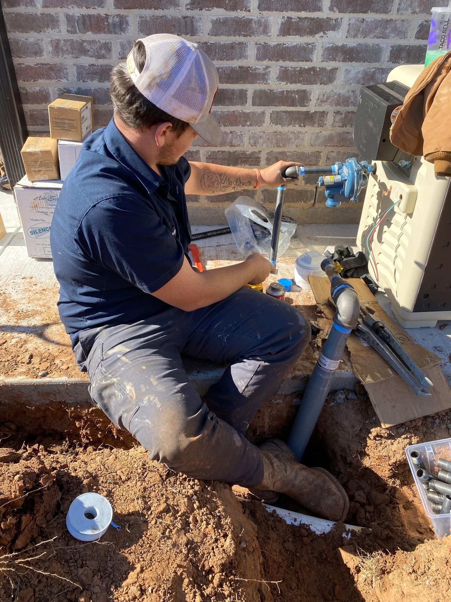 Blue Note Pros technician installing an outdoor gas line connection.