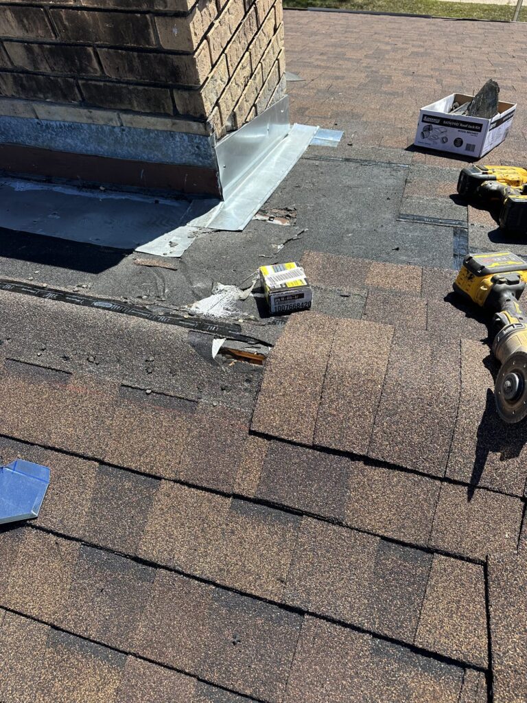 Blue Note Pros repairing chimney base flashing on a shingle roof