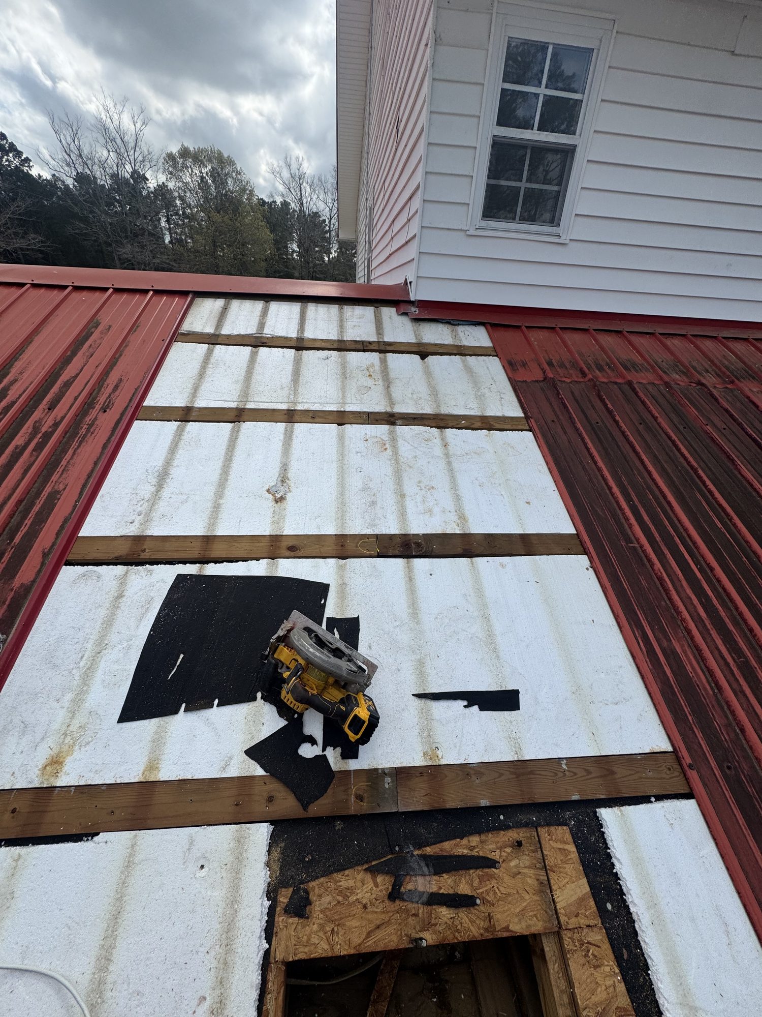 Blue Note Pros repairing a metal roof leak and damaged decking