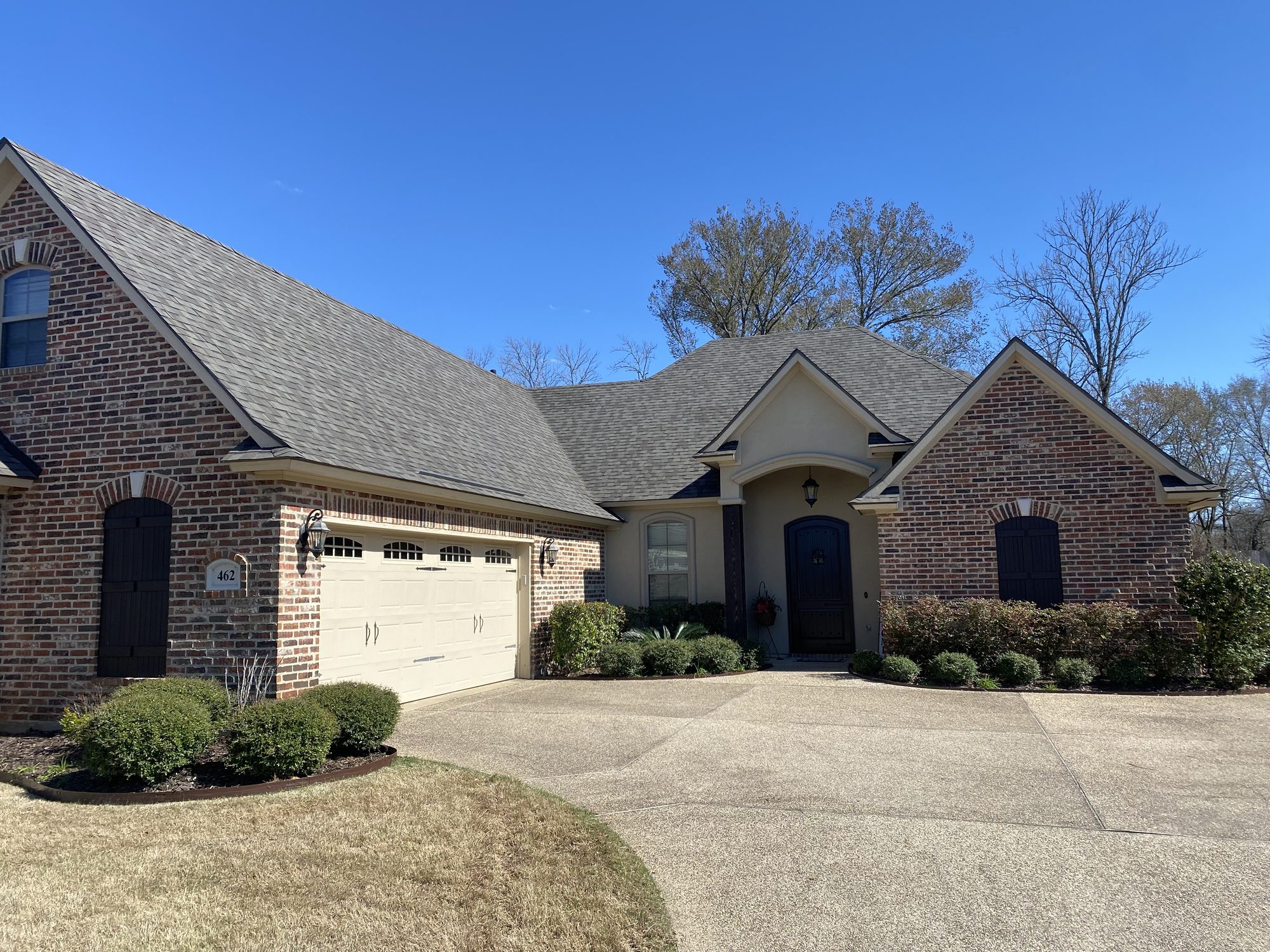 Brick home with new architectural shingles installed by Blue Note Pros