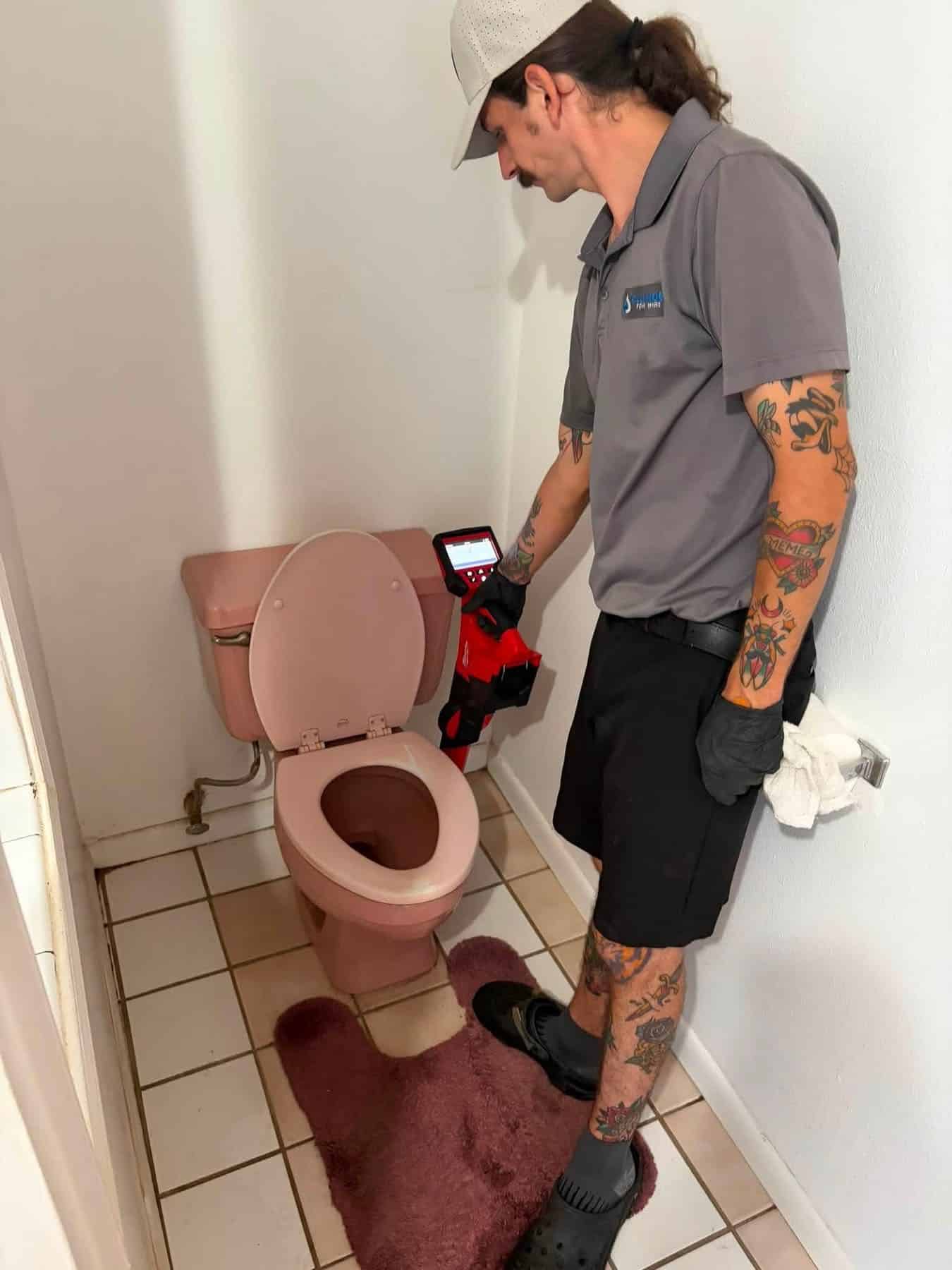 Blue Note Pros plumber running a sewer camera inspection through a toilet drain