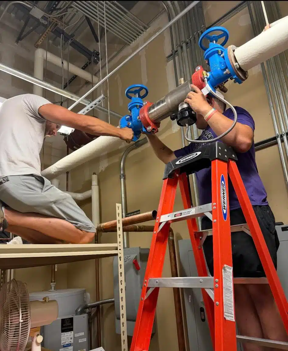 Plumber installing and servicing a water heater