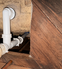 Plumber inspecting a water leak inside a home